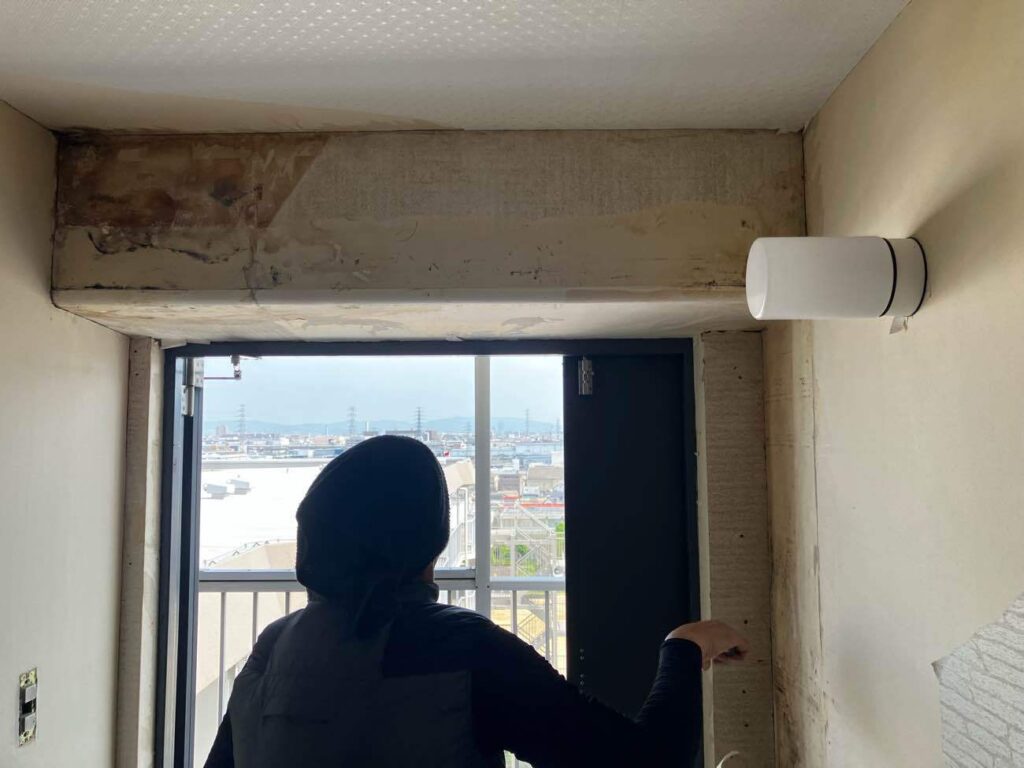 玄関のクロスの下に生えたカビ